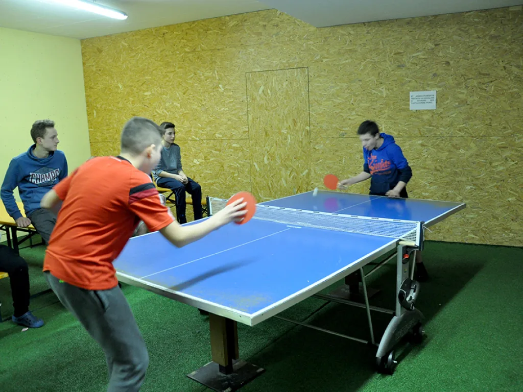 Jugendlicher schlägt beim Tischtennis auf.